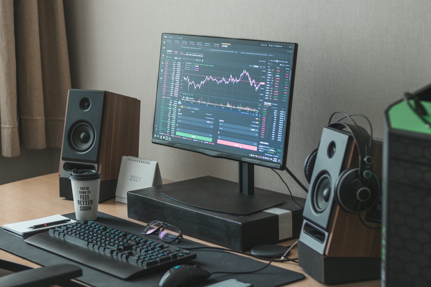 Computer monitor with charts on a wooden desk in a home office.