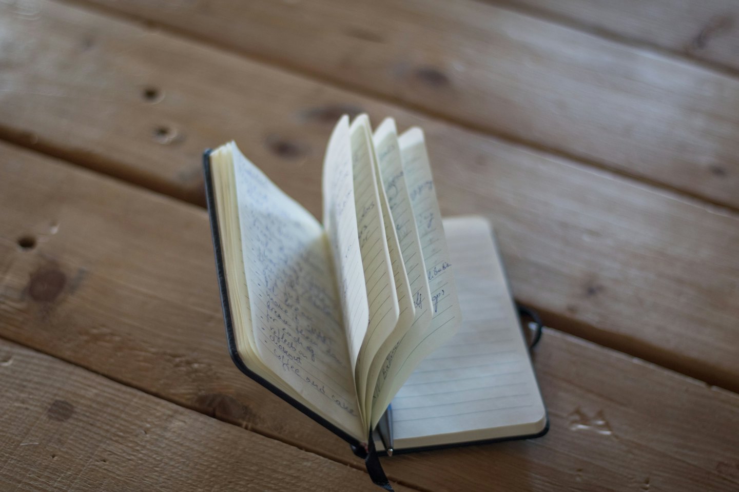 Open notebook with handwritten notes rests on a wooden table.